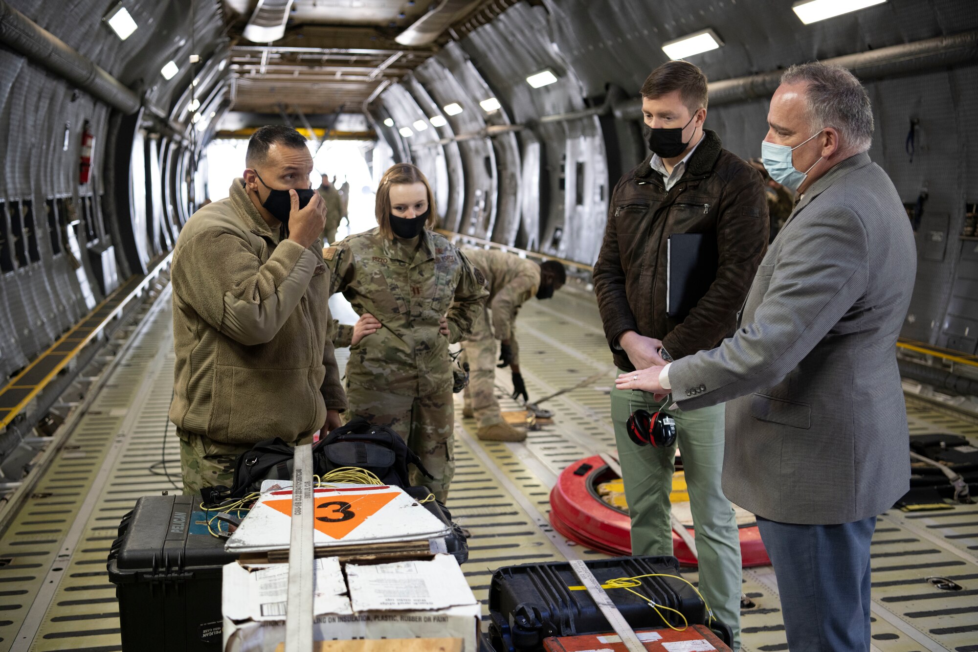 U.S. Air Force Master Sgt. Mario Hernandez, left, 60th Aircraft Maintenance Squadron home station flight chief, speaks with Steve Conley, second right, and Erik Klein, right both senior research associates at Georgia Tech Research Institute, during a home station check inspection development initiative March 18, 2021, at Travis Air Force Base, California. Airmen collaborated with the Air Staff Logistics Directorate’s Tesseract team and key partners from the C-5 program office to implement commercial maintenance practices in scheduling and completing maintenance around flying demands. (U.S. Air Force photo by Airman 1st Class Alexander Merchak)