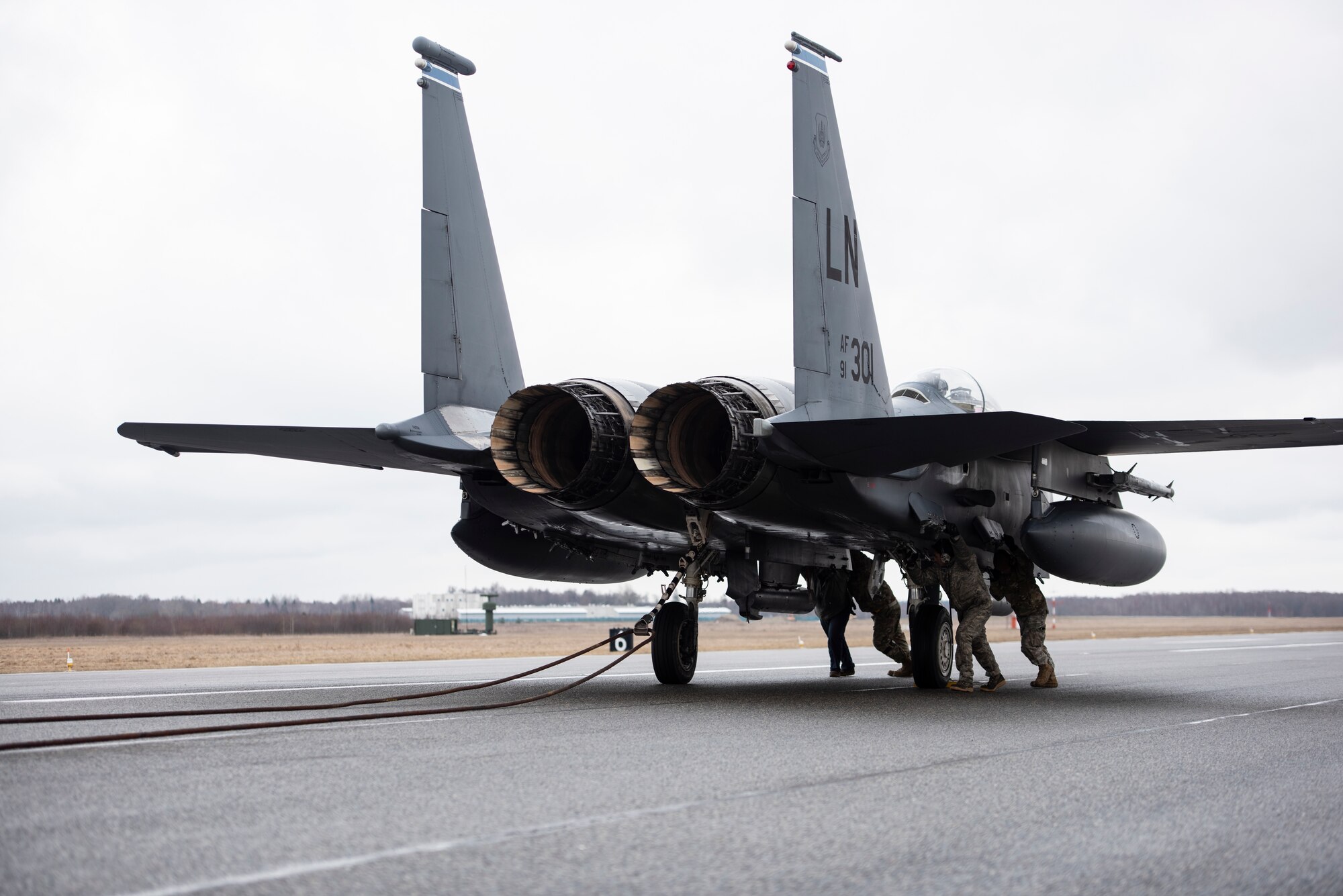 Airmen assigned to the 48th Aircraft Maintenance Squadron work to release the cable from the tailhook of a 492nd Fighter Squadron F-15E Strike Eagle during a Barrier Arresting Kit certification at Ämari Air Base, Estonia, March 17, 2021. The BAK is certified annually to test the stability and effectiveness of the system, which acts as a braking mechanism to stop the aircraft in the event of an emergency that would prevent the aircraft from performing a standard landing. (U.S. Air Force photo by Airman 1st Class Jessi Monte)