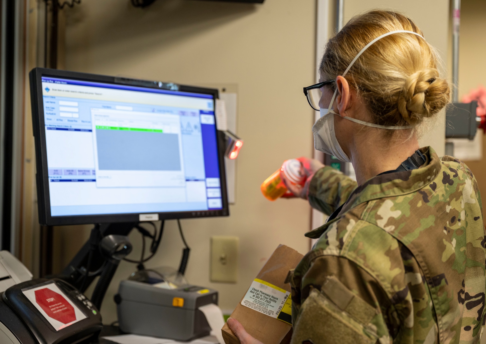 Master Sgt. Lucinda Allen, 436th Medical Support Squadron pharmacy flight chief, scans the bar code on a prescription bottle at the 436th Medical Group pharmacy on Dover Air Force Base, Delaware, March 12, 2021. Scanning the bar code of a prescription ensures the medication is delivered to the right patient, and keeps records of when a patient picked up their medication. (This photo has been digitally enhanced to protect patient information) (U.S. Air Force photo by Airman 1st Class Cydney Lee)
