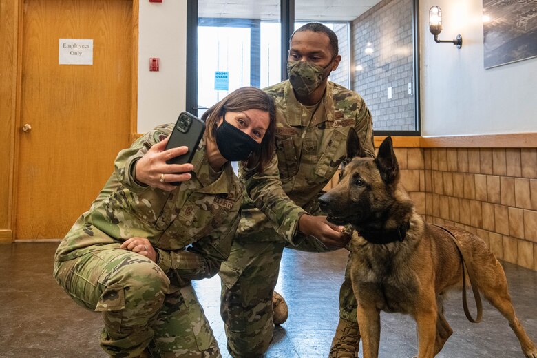 Chief Master Sergeant of the Air Force JoAnne S. Bass takes a photo with Staff Sgt. DeAndre Turner, 97th Security Forces Squadron military working dog handler, March 22, 2021, at Altus Air Force Base, Okla. Bass visited the 97th Medical Group, 97th Logistics Readiness Squadron, and 97th Maintenance Group, among other locations.