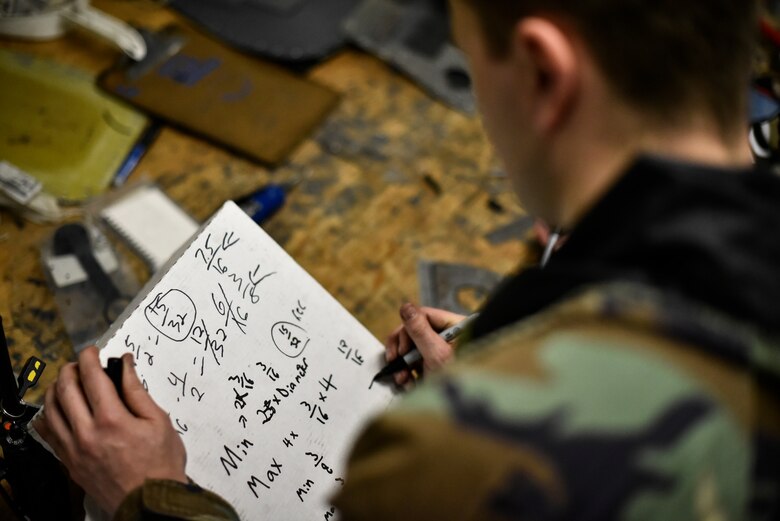 Airmen use tools to repair an aircraft component.