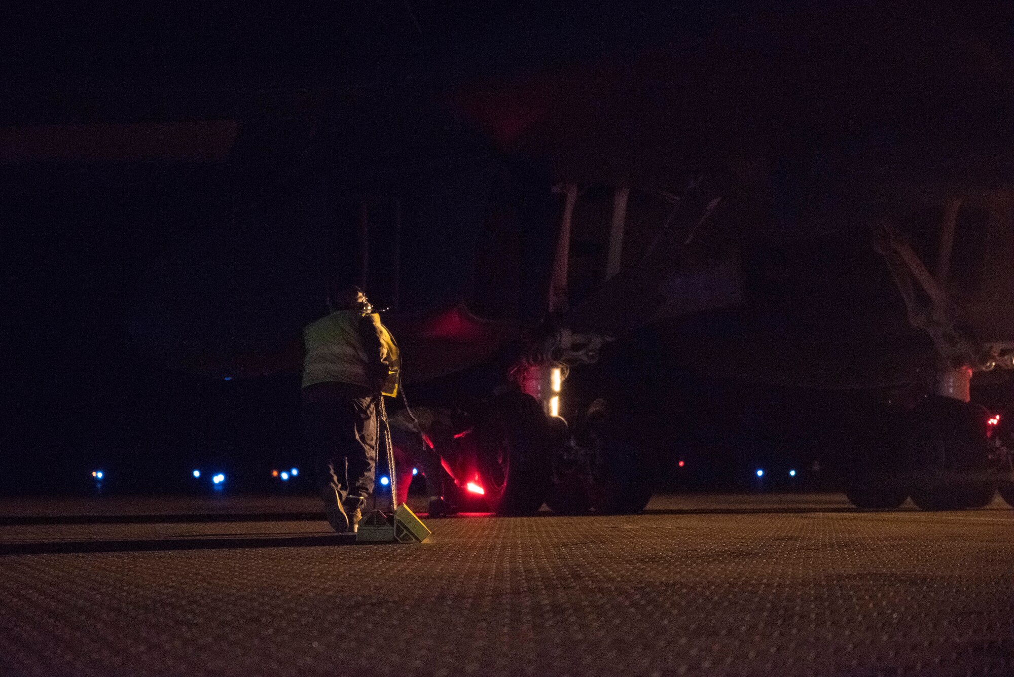 A crew chief assigned to the 9th Expeditionary Bomb Squadron drags aircraft tire chocks toward the rear landing gear of a B-1B Lancer at Ørland Air Force Station, Norway, March 19, 2021. Upon landing, aircraft maintainers are responsible for catching the jet and performing necessary immediate actions, such as chocking the tires and replacing “Remove Before Flight'' safety tags. (U.S. Air Force photo by Airman 1st Class Colin Hollowell)