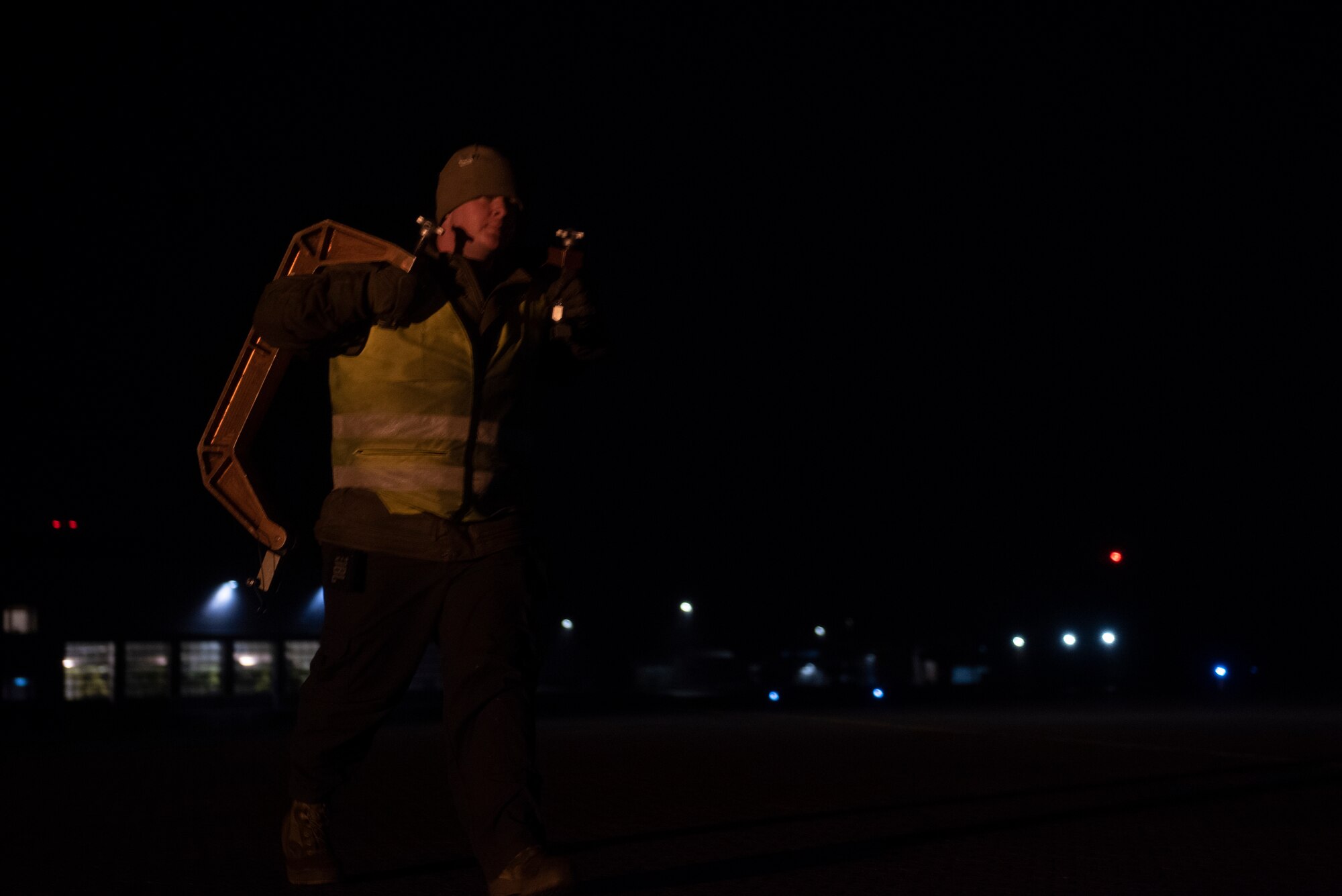 A crew chief assigned to the 9th Expeditionary Bomb Squadron carries two landing gear clamps at Ørland Air Force Station, Norway, March 19, 2021. The B-1 carries the largest payload of both guided and unguided conventional weapons in the U.S. Air Force inventory. (U.S. Air Force photo by Airman 1st Class Colin Hollowell)