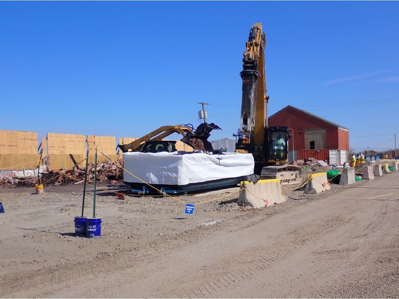 Loading a roll-off container with building debris from the Luckey Site maintenance office building deconstruction.