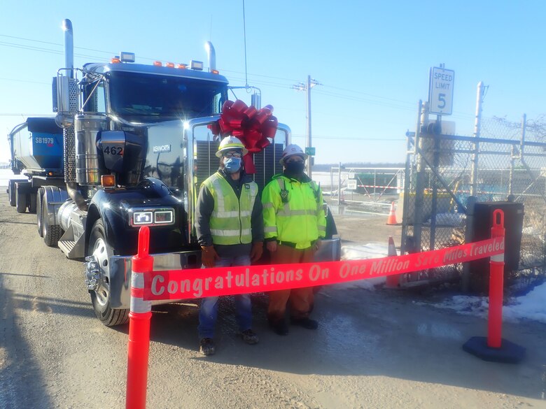 Luckey FUSRAP site team poses in front of a truck carrying contaminated soil,