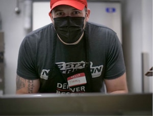 U.S. Air Force Staff Sgt. Jimmy Mrosko, an Air Guard Reserve assignment technician at Headquarters Air Reserve Personnel Center, prepares meals at Denver Rescue Mission Feb. 21, 2021, in Denver, Colo. Mrosko said, “these people are going through hard times, but I see the joy in their spirit.” (U.S. Air Force photo by Master Sgt. Leisa Grant/Released)