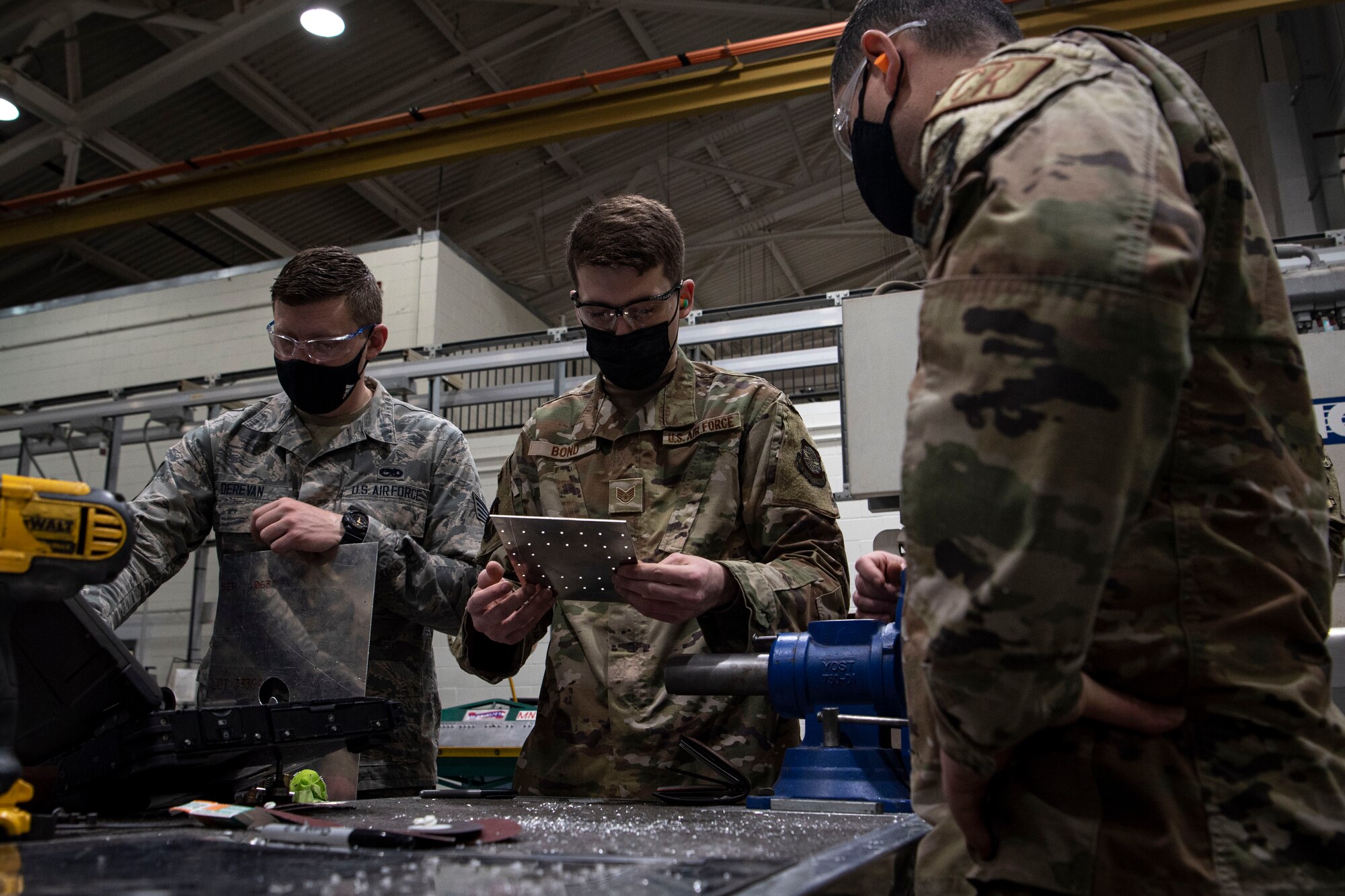 Photo of an Airman analyzing a sheet metal patch.