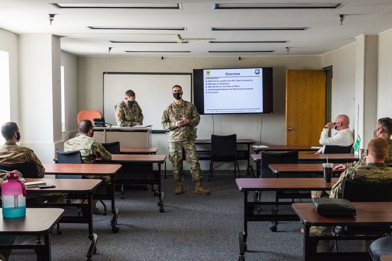 Master Sgt. Marshal Nault, 436th Airlift Wing command and control operations noncommissioned officer in charge, center, briefs wing staff agency members during the one-day extremism standdown on Dover Air Force Base, Delaware, March 19, 2021. Secretary of Defense Lloyd J. Austin III directed a departmentwide standdown to discuss problems of extremism in the ranks and train members on taking appropriate action to combat extremism. (U.S. Air Force photo by Roland Balik)