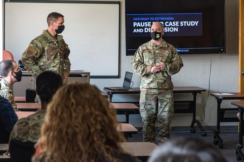 Col. Shanon Anderson, 436th Airlift Wing vice commander, left, listens to Chief Master Sgt. Jeremiah Grisham, 436th AW interim command chief, as he addresses wing staff agency members during the one-day extremism standdown on Dover Air Force Base, Delaware, March 19, 2021. Unit facilitators used the Pathway to Extremism curriculum to educate Team Dover Airmen and Guardians. (U.S. Air Force photo by Roland Balik)