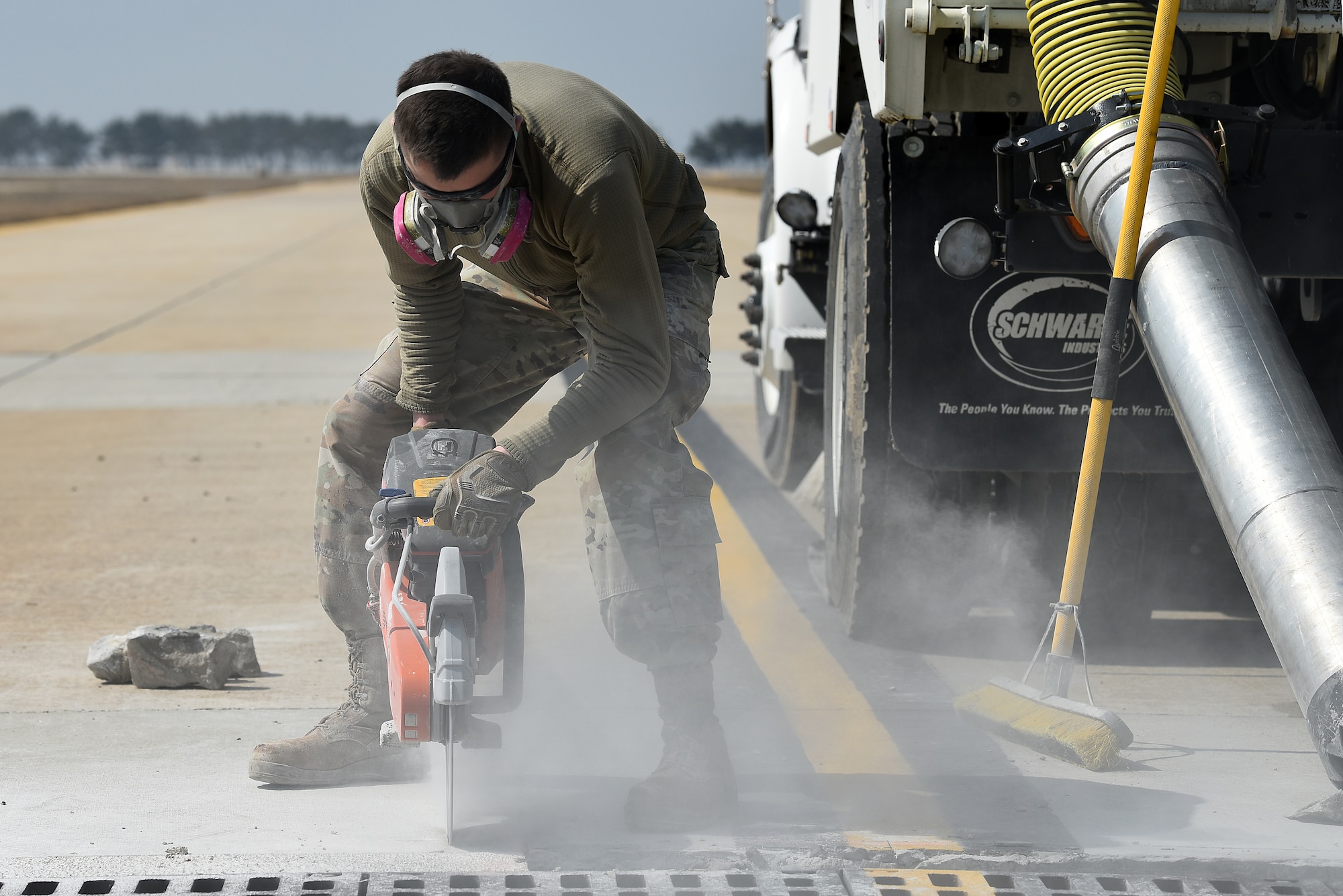 Airman 1st Class Chase Pavlenko, 8th Civil Engineer Squadron pavements and heavy equipment operator, uses a K-12 saw to cut out cracked concrete on a taxiway at Kunsan Air Base, Republic of Korea, March 23, 2021. The 8th CES is replacing failed concrete on the flightline to prevent foreign object debris hazards. (U.S. Air Force photo by Senior Airman Suzie Plotnikov)