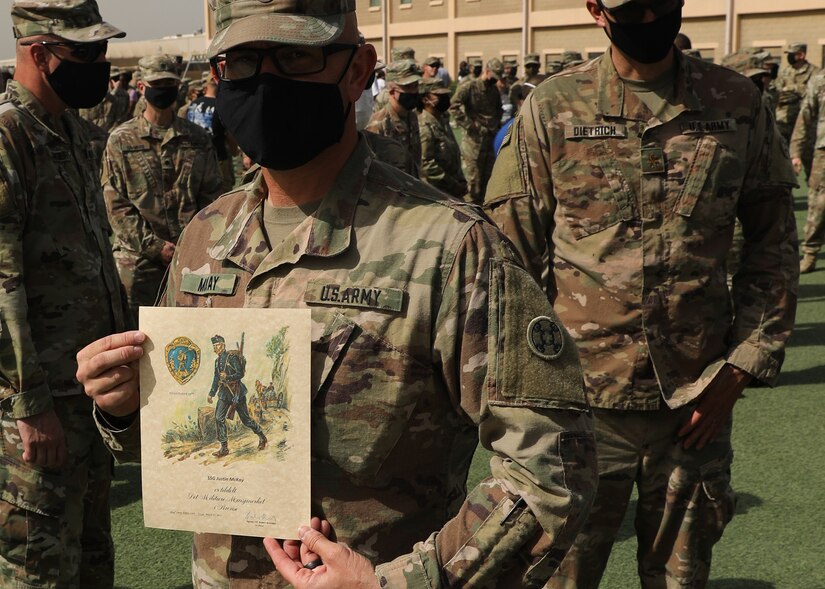 Army Reserve Staff Sgt. Justin McKay, who is deployed to Camp Arifjan, Kuwait, with the 310th Sustainment Command (Expeditionary), holds his Norwegian Foot March certificate after the March 21, 2021 recognition ceremony. McKay, a combat medic, said it was his third time completing the 18.6-mile course with a 25-pound ruck under the time limit for his age group. (U.S. Army photo by Staff Sgt. Neil W. McCabe)