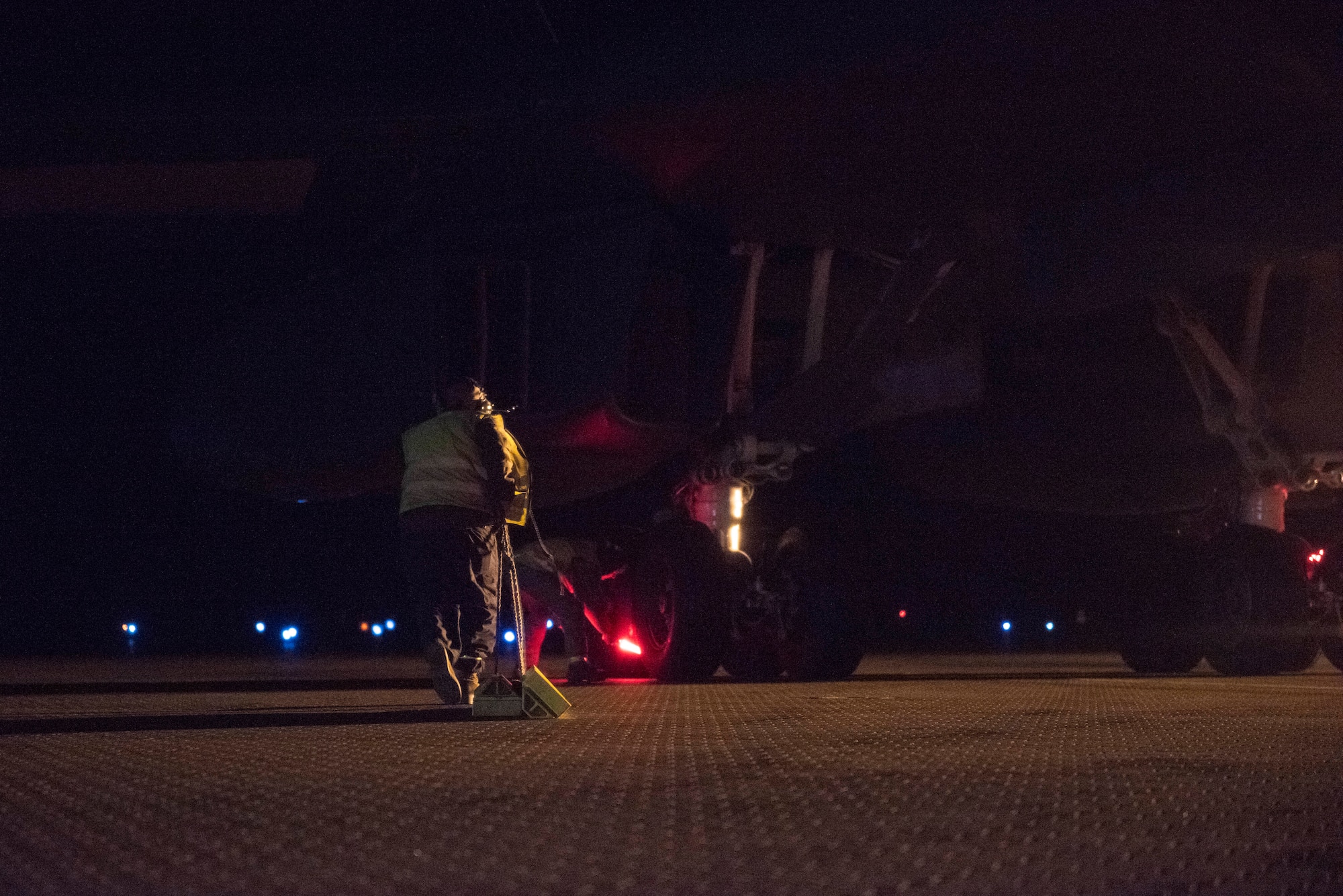 A crew chief assigned to the 9th Expeditionary Bomb Squadron drags aircraft tire chocks toward the rear landing gear of a B-1B Lancer at Ørland Air Force Station, Norway, March 19, 2021. Upon landing, aircraft maintainers are responsible for catching the jet and performing necessary immediate actions, such as chocking the tires and replacing “Remove Before Flight'' safety tags. (U.S. Air Force photo by Airman 1st Class Colin Hollowell)