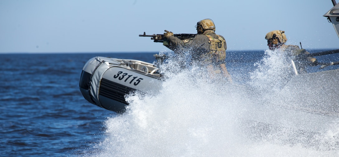 U.S. Coast Guardsmen with a Maritime Security Response Team fire an M240B machine gun from a response boat during advanced interdiction training near Bombing Target 9, N.C., March 9.