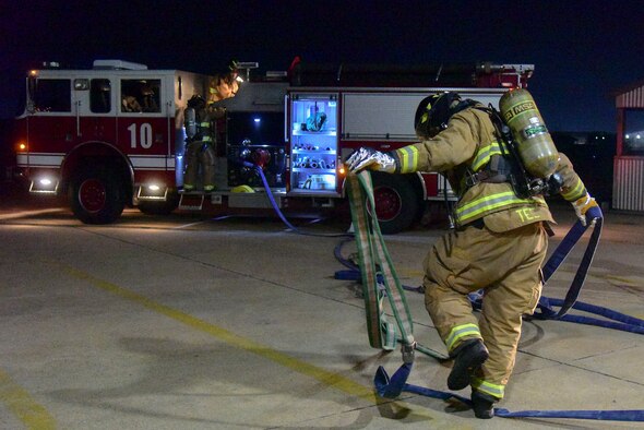 Senior Airman Orlando Teel, 8th Civil Engineer Squadron firefighter, pulls a hose line at Kunsan Air Base, Republic of Korea, March 23, 2021. Firefighters respond to emergencies from brush fires to burning rocket fuel and hazardous material fires to ensure the safety of others. (U.S. Air Force photo by Senior Airman Suzie Plotnikov)