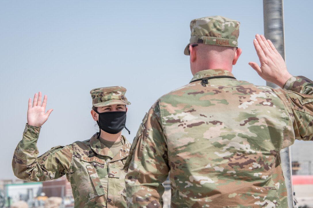 Airmen recite the oath of enlistment with arm raised
