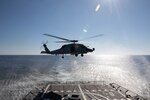 A MH-60R Seahawk helicopter, attached to the Helicopter Maritime Strike Squadron (HSM) 79, departs the flight deck of the Arleigh Burke-class guided-missile destroyer USS Roosevelt (DDG 80), March 23, 2021.