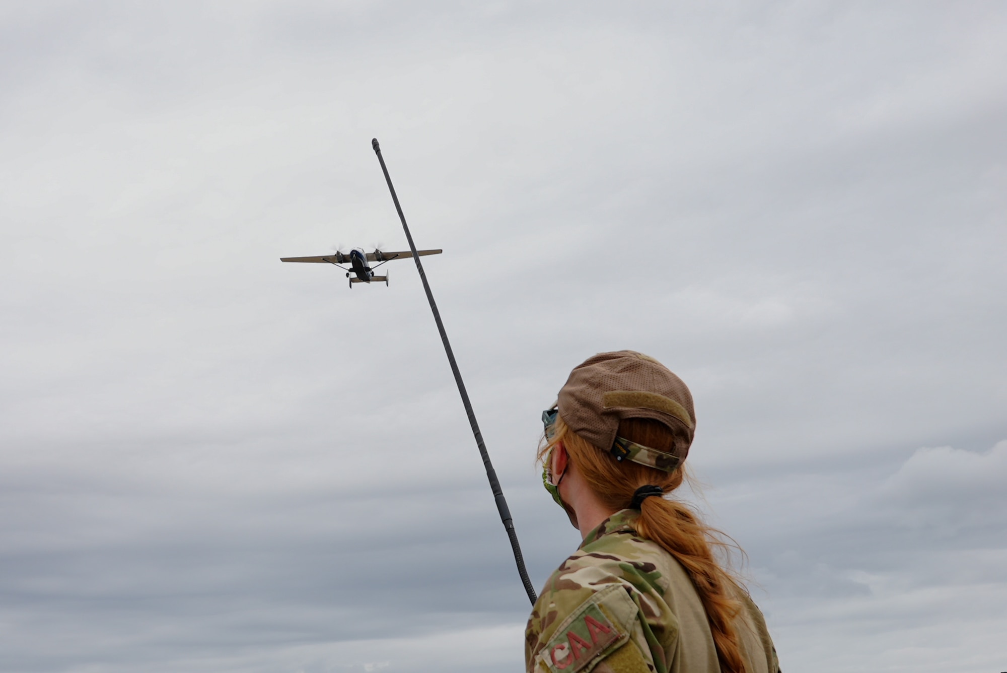 Photo of Airman looking at a plane flying