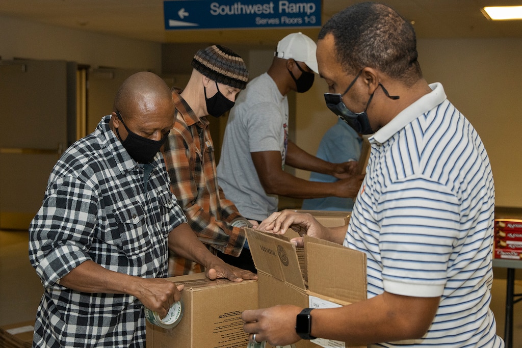 Command Sgt. Maj. Kenneth F. Law, U.S. Army Financial Management Command senior enlisted advisor, left, and Ronald Houston, USAFMCOM Army Military Pay Office site captain, right, build boxes for Soldier care packages at the Maj. Gen. Emmett J. Bean Federal Center in Indianapolis March 6, 2021. Law and Houston joined other Army Soldiers, civilian employees, veterans and retirees to make care packages, which will be sent to deployed Soldiers of the U.S. Army Reserve’s 310th Expeditionary Sustainment Command. (U.S. Army photo by Mark R. W. Orders-Woempner)