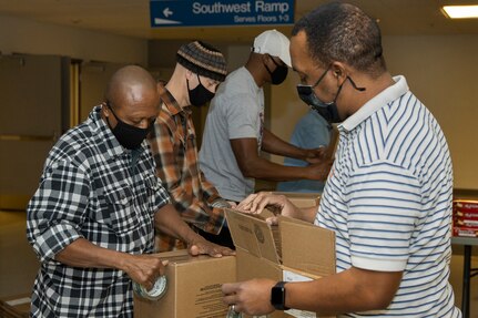 Command Sgt. Maj. Kenneth F. Law, U.S. Army Financial Management Command senior enlisted advisor, left, and Ronald Houston, USAFMCOM Army Military Pay Office site captain, right, build boxes for Soldier care packages at the Maj. Gen. Emmett J. Bean Federal Center in Indianapolis March 6, 2021. Law and Houston joined other Army Soldiers, civilian employees, veterans and retirees to make care packages, which will be sent to deployed Soldiers of the U.S. Army Reserve’s 310th Expeditionary Sustainment Command. (U.S. Army photo by Mark R. W. Orders-Woempner)