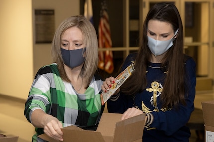 Valerie Dillion, U.S. Army Financial Management Command secretary to the general staff, left, and Liv Marvin, USAFMCOM assistant inspector general, fill Soldier care packages at the Maj. Gen. Emmett J. Bean Federal Center in Indianapolis March 6, 2021. Dillon and Marvin joined Army Soldiers, civilian employees, veterans and retirees to make care packages, which will be sent to deployed Soldiers of the U.S. Army Reserve’s 310th Expeditionary Sustainment Command. (U.S. Army photo by Mark R. W. Orders-Woempner)