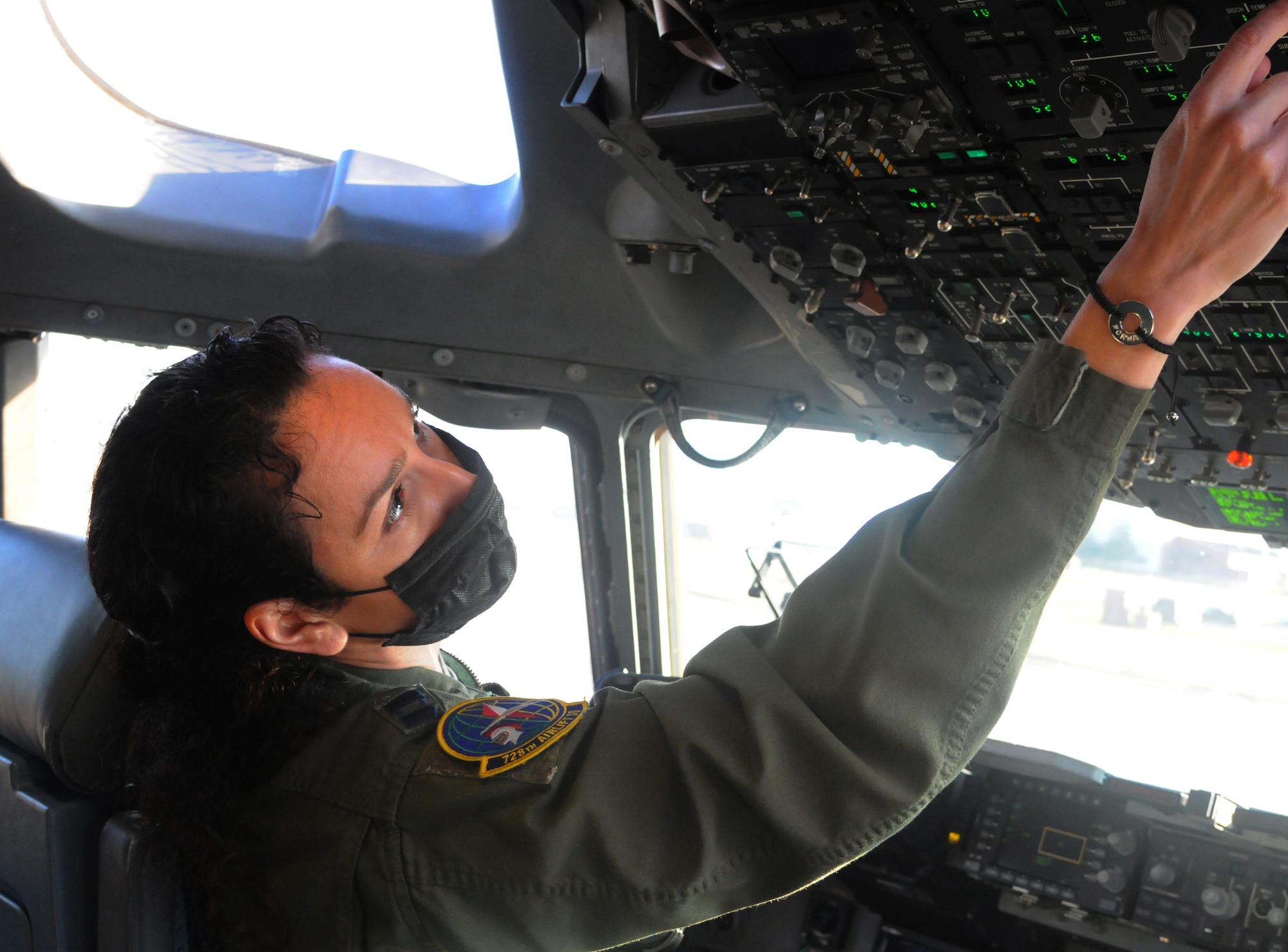 Capt. Fidan Thornburg, a pilot assigned to the 728th Airlift Squadron, performs pre-fight checks in a C-17 Globemaster III before takeoff March 11 at McChord Field, Washington.
