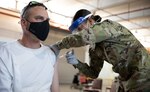 A member of the New Mexico National Guard administers a COVID-19 vaccine at the Wyoming Readiness Center in Albuquerque, N.M., March 18, 2021. The NMNG and active-duty  Air Force vaccinated about 400 eligible Department of Defense service members, federal technicians, contractors and others.