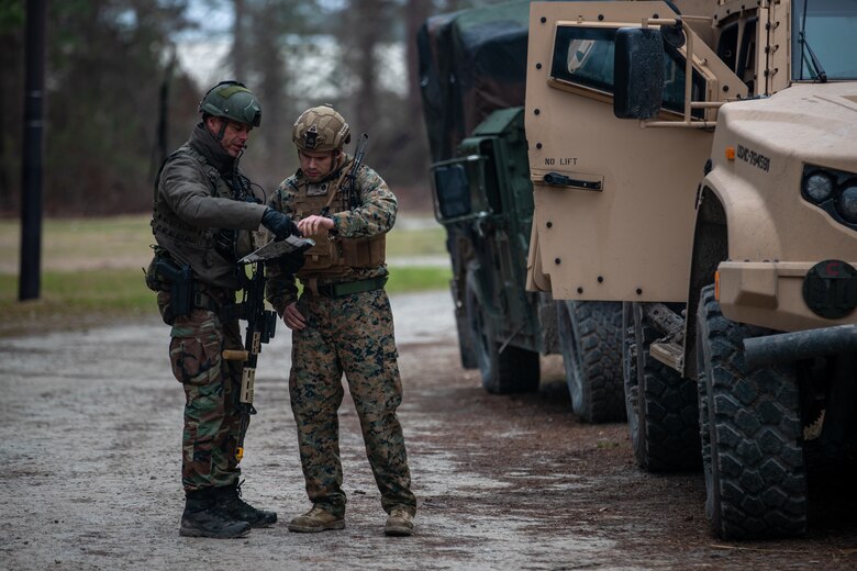 A Dutch Marine with 32nd Raiding Squadron, left, and U.S. Marine Corps Staff Sgt. Brady Parks, a native of Logan, Ohio, and a maintenance chief with 2d Reconnaissance Battalion (Recon Bn.), 2d Marine Division, discuss a scheme of maneuver during Exercise Caribbean Urban Warrior on Camp Lejeune, N.C., March 23, 2021. The exercise is a bilateral training evolution designed to increase global interoperability between 2d Recon Bn. and 32nd Raiding Squadron, Netherlands Marine Corps. (U.S. Marine Corps photo by Lance Cpl. Jacqueline Parsons)