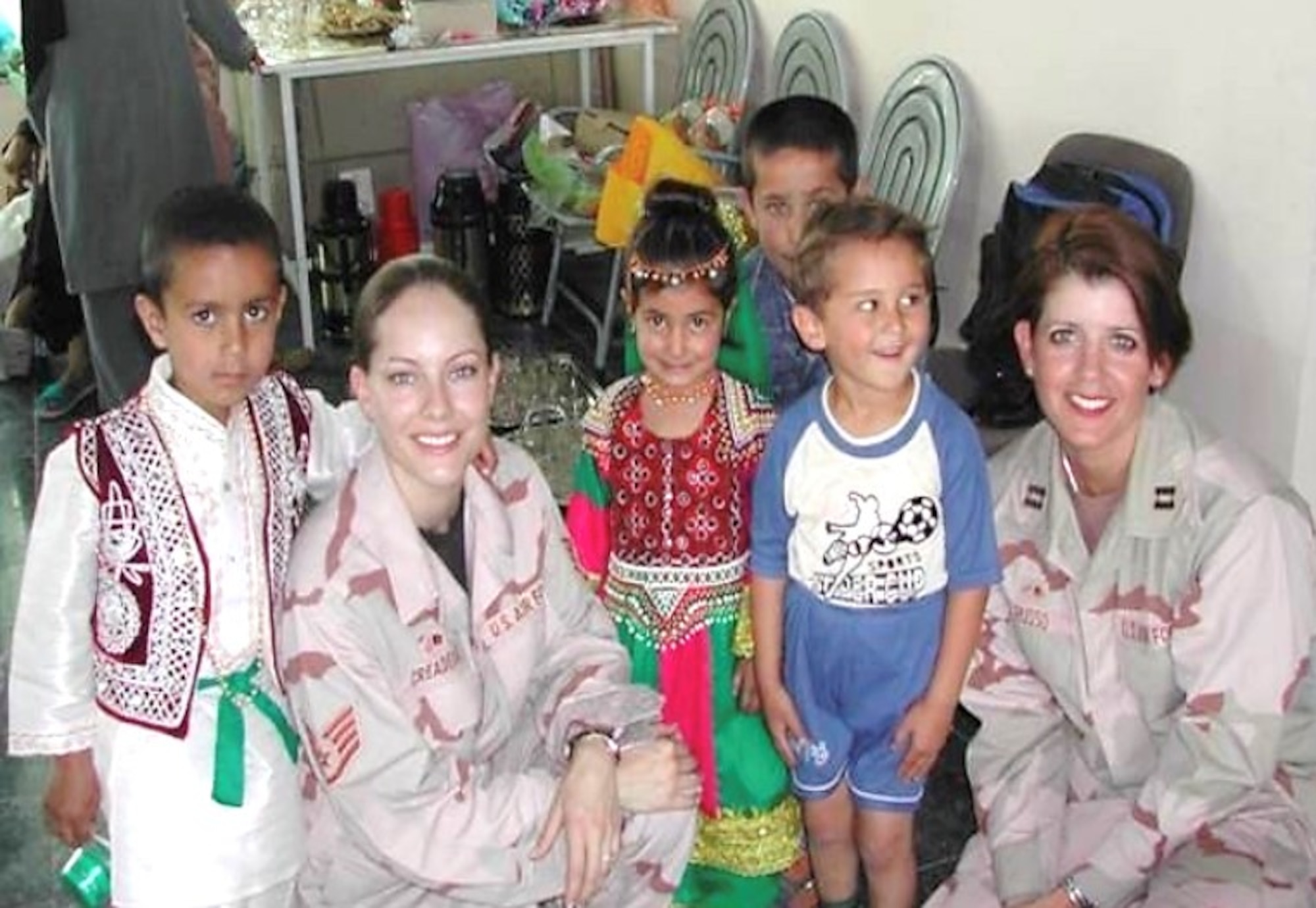 Then Staff Sgt., now Maj. Debora Berg (left), current 436th Contracting Squadron commander, and then Capt. Renee Russo (right), current 436th CONS director of business operations, worked with local children from the International School of Kabul in Kabul, Afghanistan during their  2006 deployment. Russo served as Berg’s commanding officer in 2006. Today, their roles are reversed, as Berg oversees the unit. (Courtesy photo)