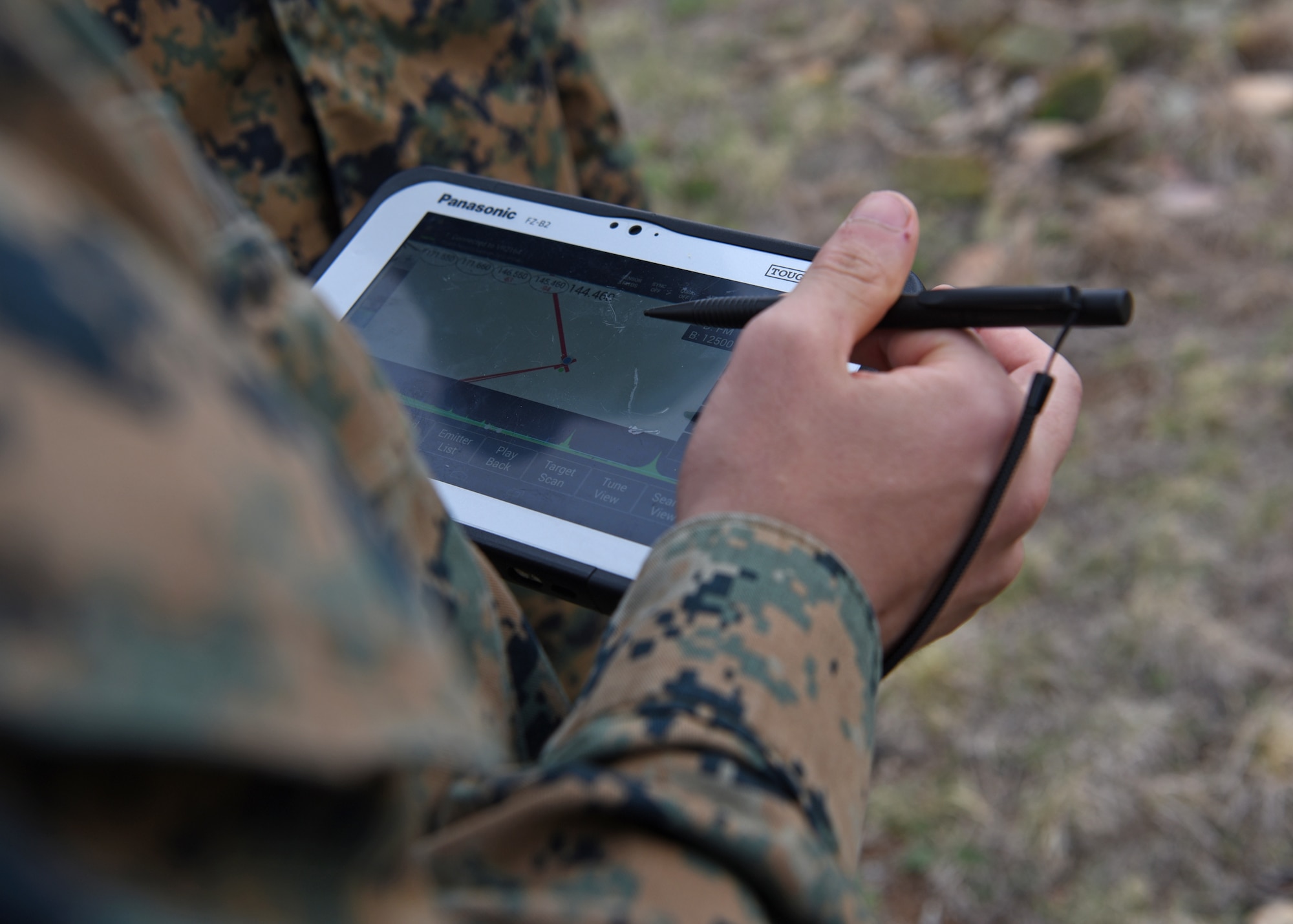 U.S. Marine Corps Pfc. Dante Rivera, Marine Corps Detachment Tactical Signals Intelligence Operator course student, analyzes a visual display of intercepted enemy radio signals during an intelligence field exercise outside of the MCD dormitories on Goodfellow Air Force Base, Texas, March 22, 2021. The electronic display provided direction and coordinates of the intercepted radio waves for Rivera and his team to physically track through the field. (U.S. Air Force photo by Senior Airman Abbey Rieves)