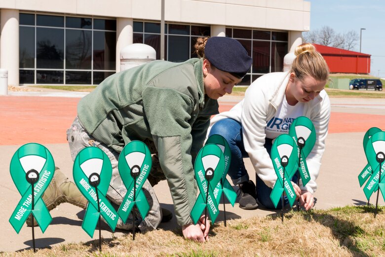 Airmen build a display of teal ribbons.