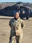 U.S. Army Chief Warrant Officer 4 Melinda Herder, District of Columbia National Guard, stands with helicopters on the flight line at Davison Army Airfield, Ft. Belvoir, Virginia. Herder is the facility maintenance officer at the D.C. National Guard Army Aviation Support Facility.