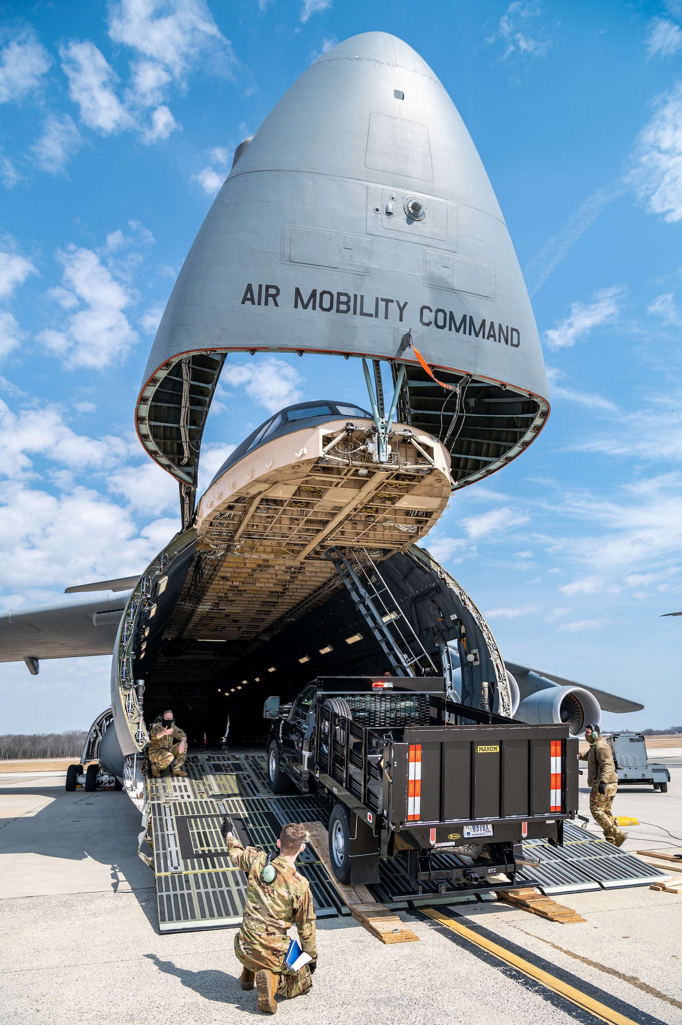A stake-bed truck is loaded onto a C-5M Super Galaxy during loadmaster training at Dover Air Force Base, Delaware, March 9, 2021. Loadmasters from the 9th Airlift Squadron participated in the training as part of a Major Command Service Tail Trainer initiative driven by Air Mobility Command. The training expedites C-5 loadmaster upgrade training, enabling Dover AFB to provide rapid global airlift. (U.S. Air Force photo by Senior Airman Christopher Quail)