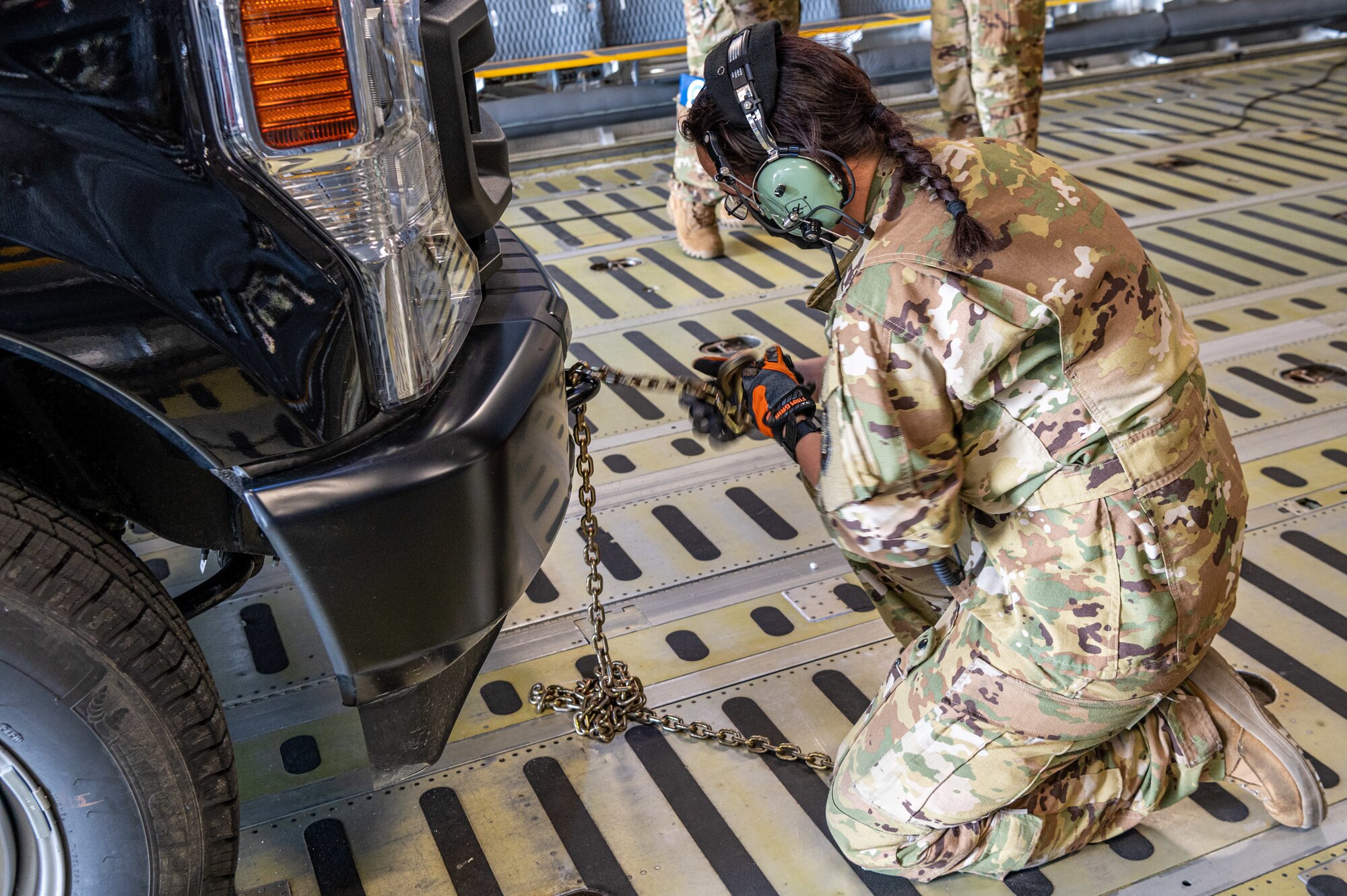 Senior Airman Rachael Hutt, 9th Airlift Squadron loadmaster, ties down a stake-bed truck onto a C-5M Super Galaxy during loadmaster training at Dover Air Force Base, Delaware, March 9, 2021. Loadmasters from the 9th Airlift Squadron participated in the training as part of a Major Command Service Tail Trainer initiative driven by Air Mobility Command. The training expedites C-5 loadmaster upgrade training, enabling Dover AFB to provide rapid global airlift.  (U.S. Air Force photo by Senior Airman Christopher Quail)