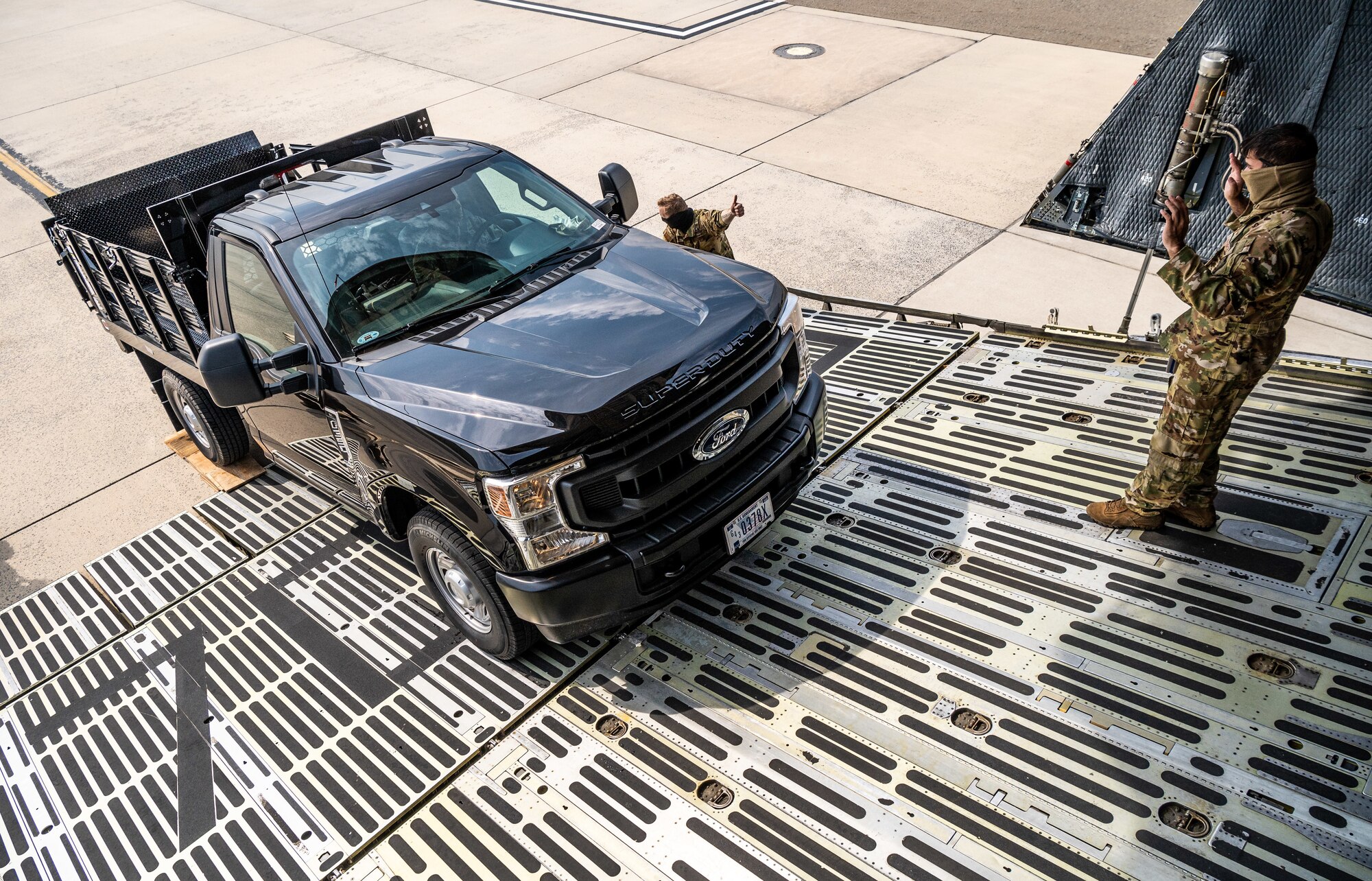 A stake-bed truck is unloaded from a C-5M Super Galaxy during loadmaster training at Dover Air Force Base, Delaware, March 9, 2021. Loadmasters from the 9th Airlift Squadron participated in the training as part of a Major Command Service Tail Trainer initiative driven by Air Mobility Command. The training expedites C-5 loadmaster upgrade training, enabling Dover AFB to provide rapid global airlift. (U.S. Air Force photo by Senior Airman Christopher Quail)