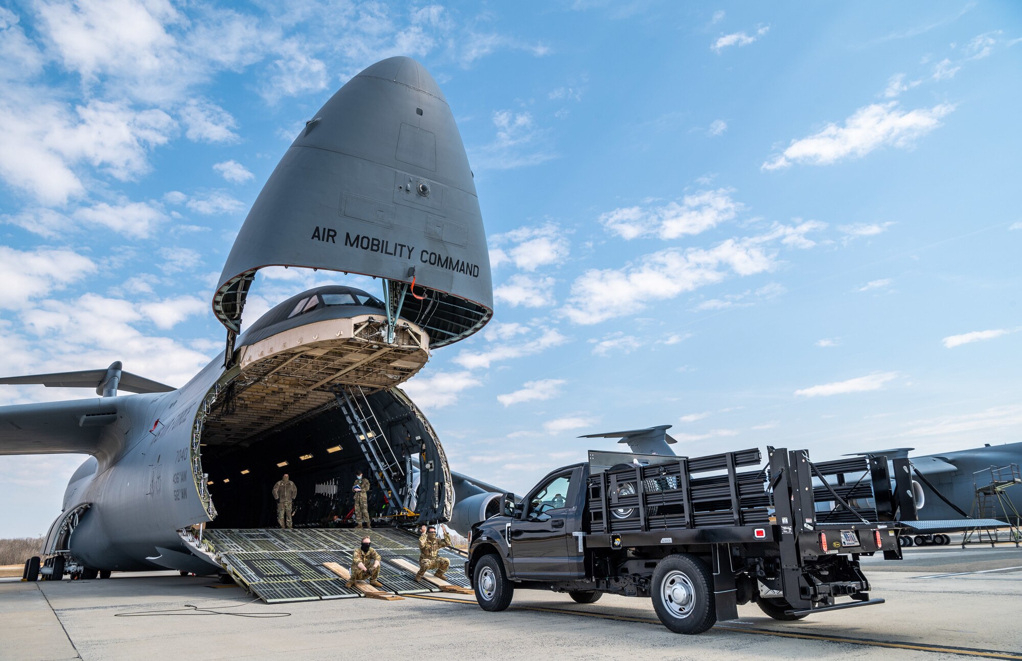 A stake-bed truck is loaded onto a C-5M Super Galaxy during loadmaster training at Dover Air Force Base, Delaware, March 9, 2021. Loadmasters from the 9th Airlift Squadron participated in the training as part of a Major Command Service Tail Trainer initiative driven by Air Mobility Command. The training expedites C-5 loadmaster upgrade training, enabling Dover AFB to provide rapid global airlift. (U.S. Air Force photo by Senior Airman Christopher Quail)