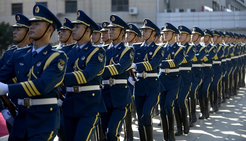 Chinese military service  members march in formation.