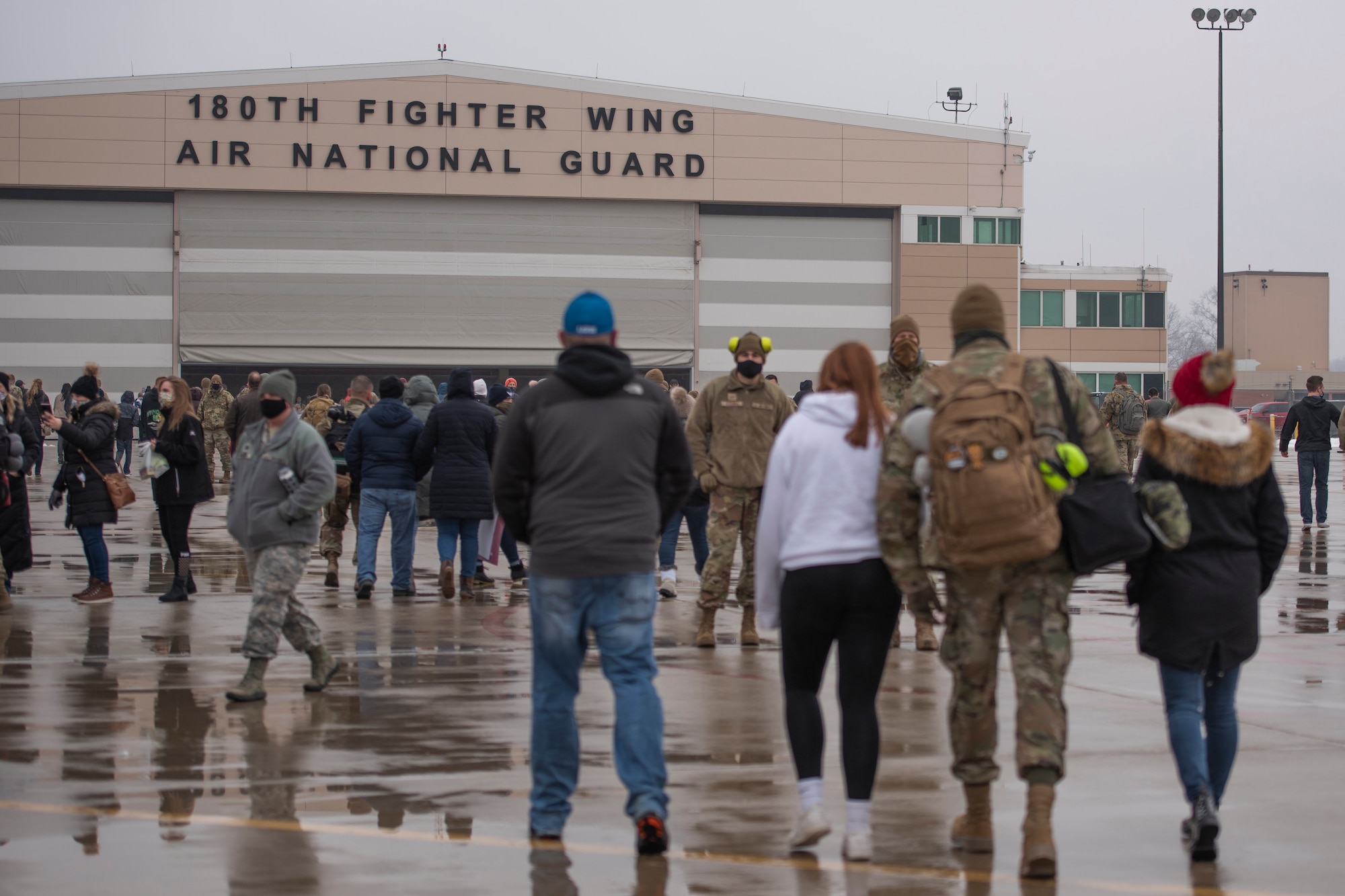 Friends and family walk to the hanger with Airmen who have returned home from their overseas deployment, Jan. 26, 2020 at the 180FW in Swanton, Ohio.