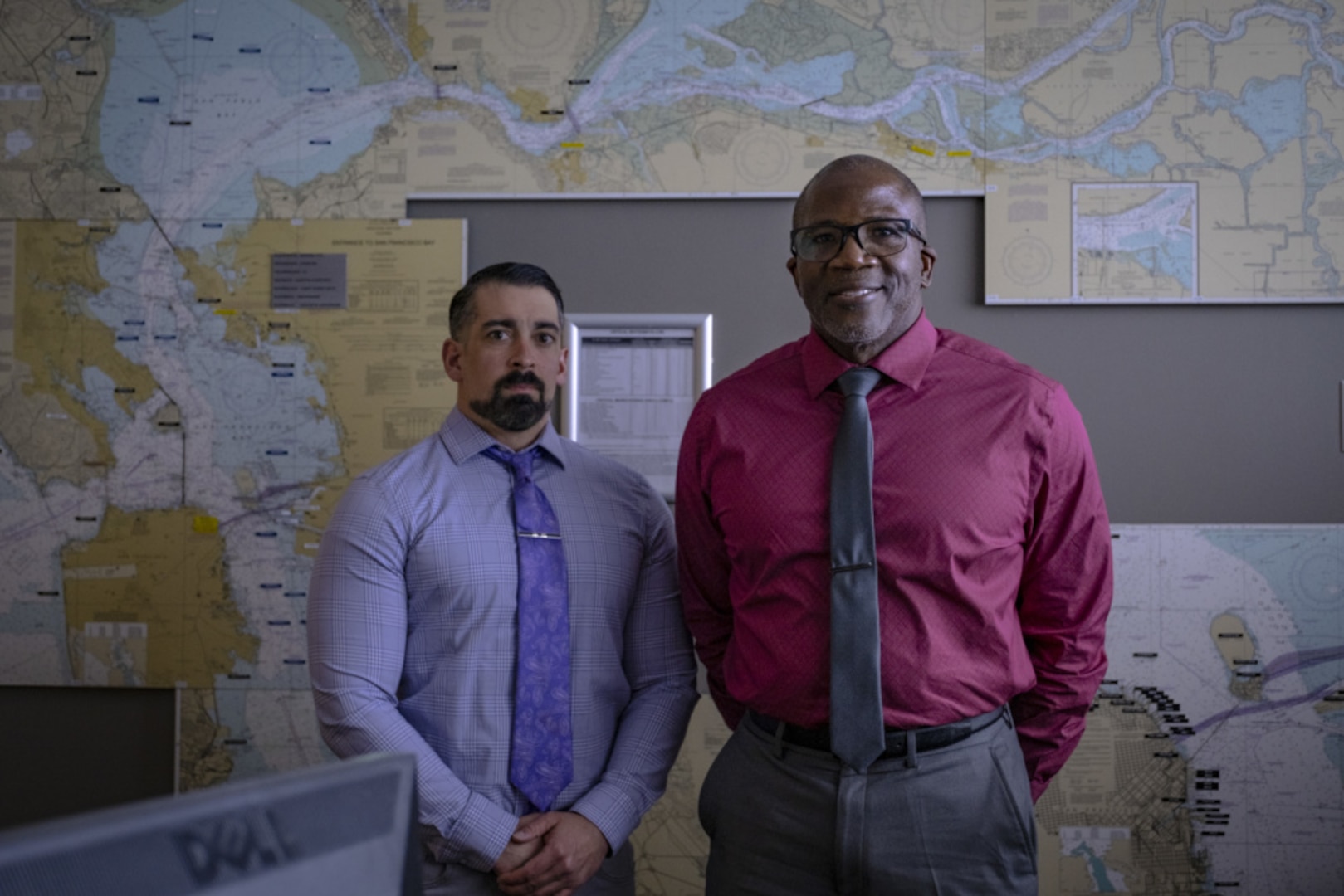 Travis Addison, a Coast Guard Sector San Francisco civilian search-and-rescue controller, and Joseph Ford, a San Francisco command duty officer, stand for a portrait phone in the Sector San Francisco command center, March 4, 2021. Addison and Ford coordinated the rescue of a young woman who entered the water with no flotation device on January 31, 2021. (U. S. Coast Guard photo by Petty Officer 2nd Class Brandon Giles)