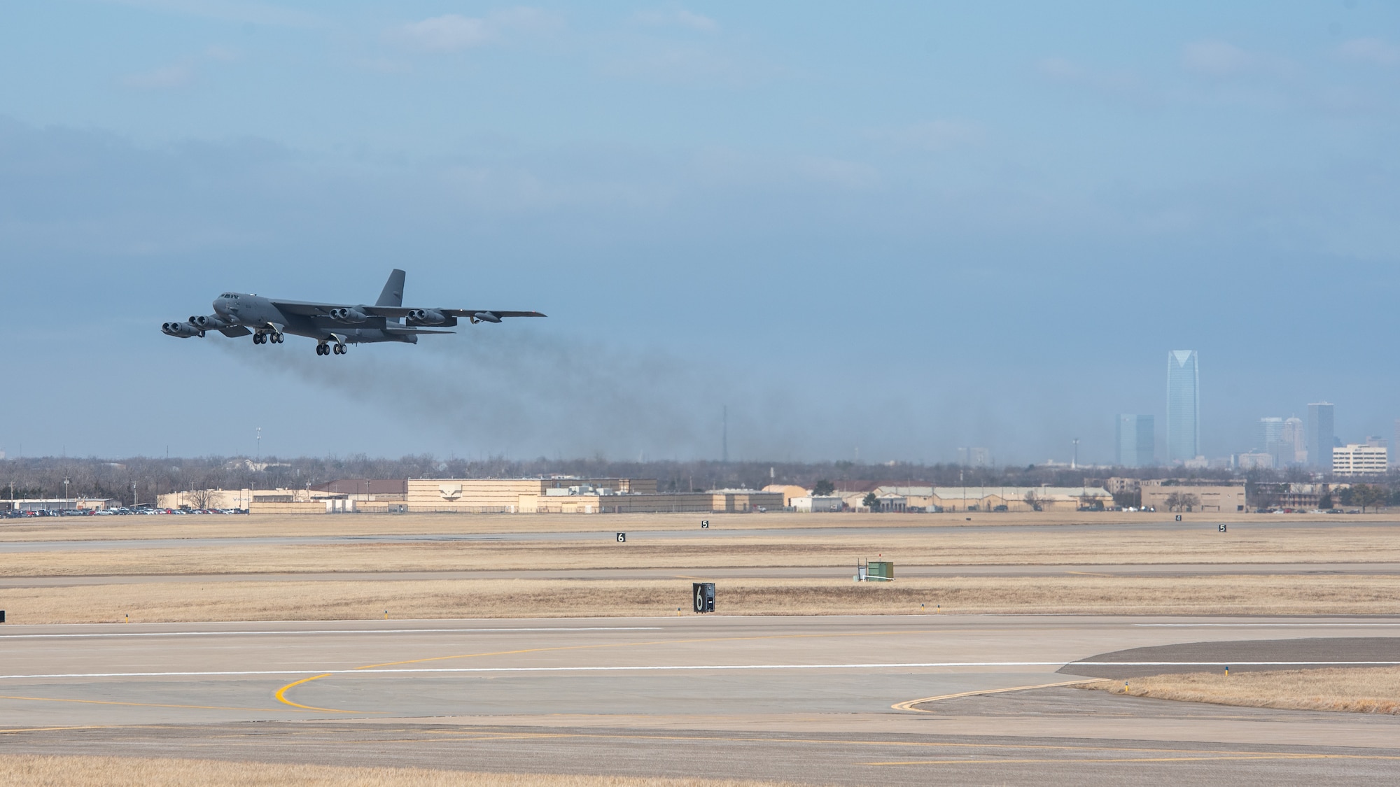 Airplane taking off with Oklahoma City downtown in background