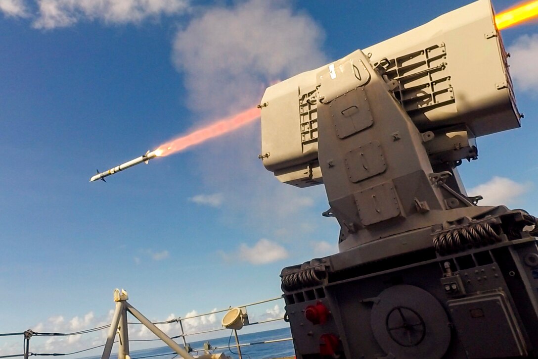 A ship fires a missile at sea.