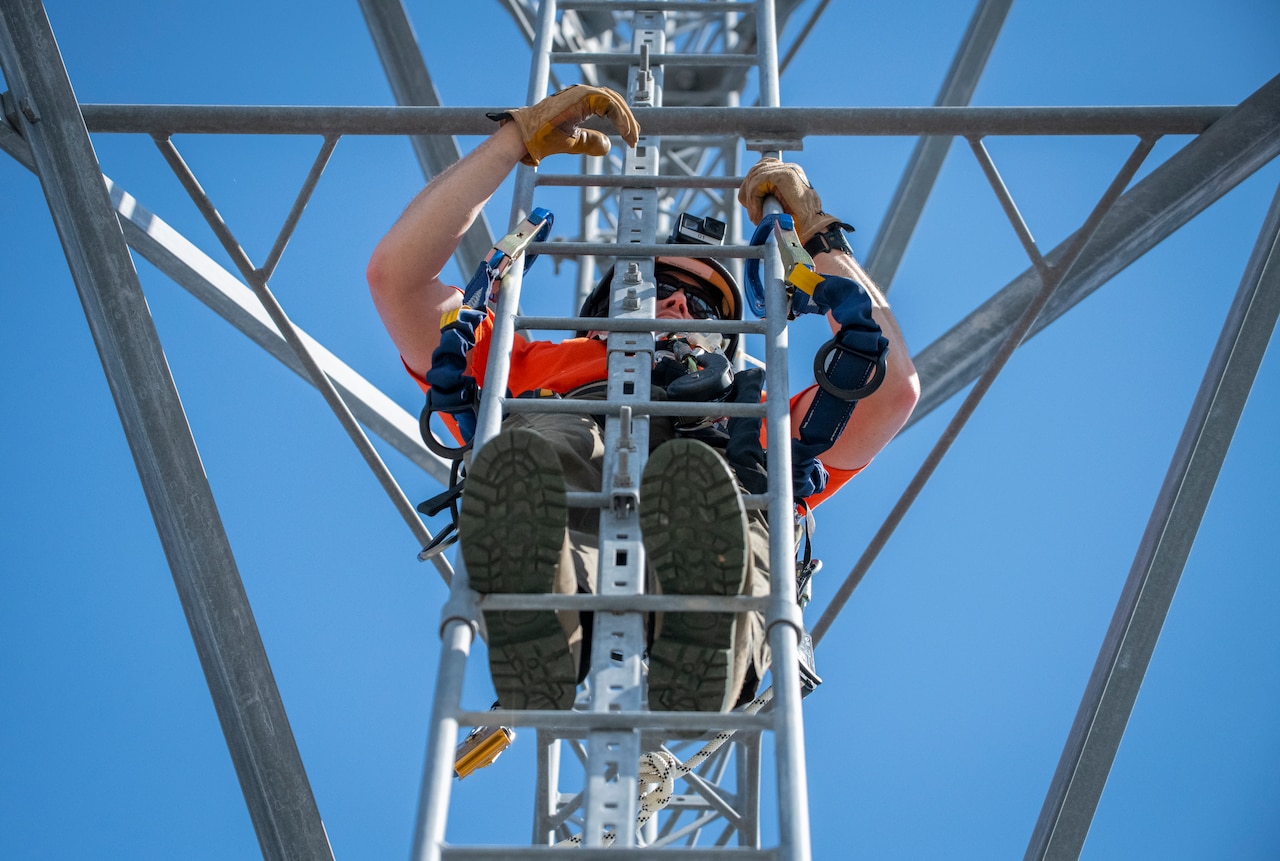 A man climbs a tower.