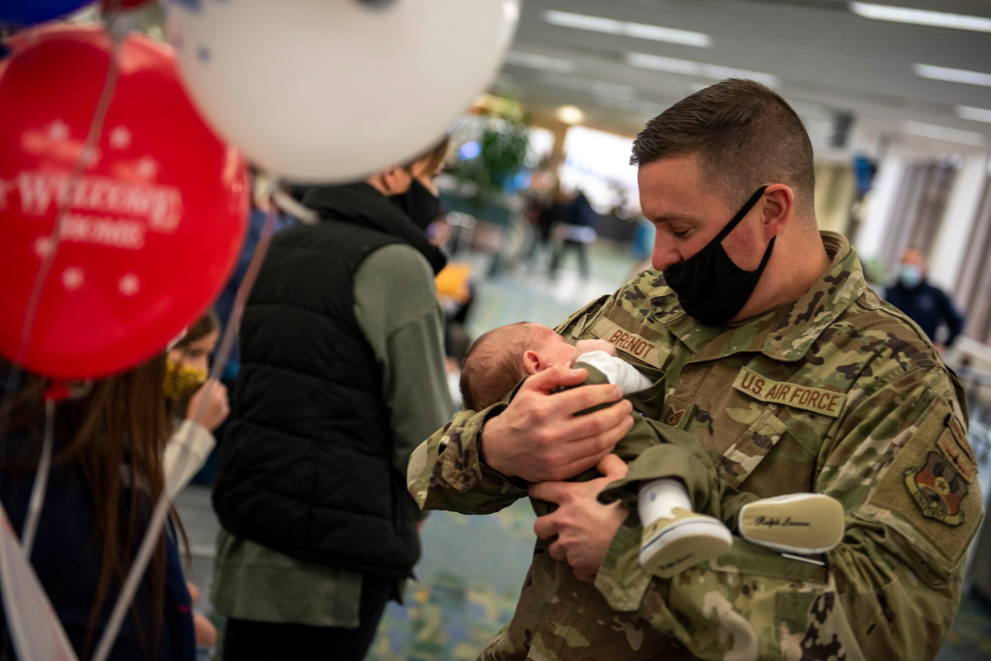 A U.S. Airman, assigned to the Ohio National Guard’s 180th Fighter Wing, holds his child for the first time after returning home from an overseas deployment, Dec. 31, 2020 at the Eugene F. Kranz Toledo Express Airport.