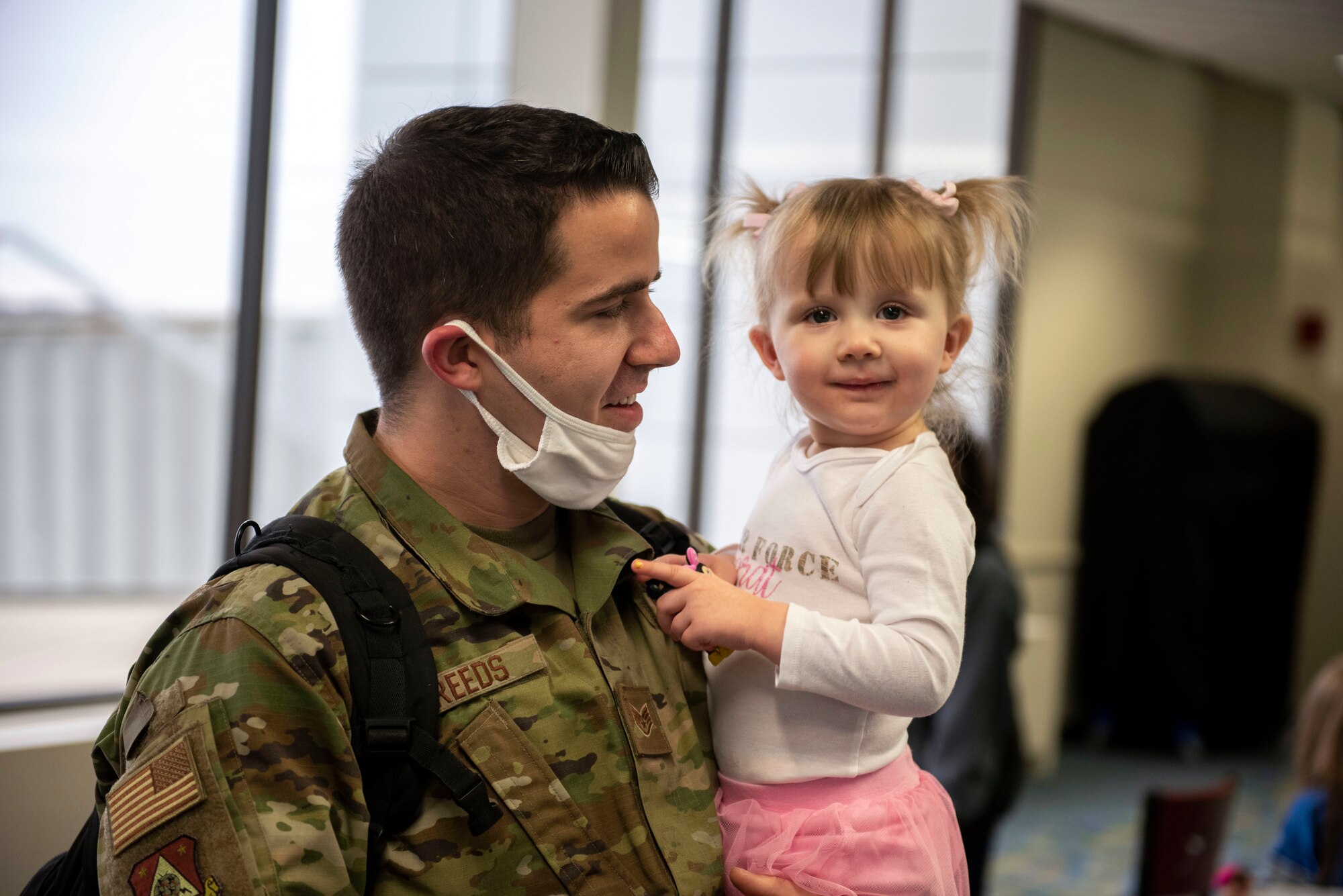 A U.S. Airman, assigned to the Ohio National Guard’s 180th Fighter Wing, holds his child after returning from an overseas deployment, Dec. 31, 2020 at the Eugene F. Kranz Toledo Express Airport.
