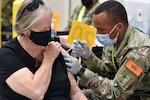 Private Anoumou Game (right), a 68C Practical Nursing Specialist student assigned to the 264th Medical Battalion, 32nd Medical Brigade, U.S. Army Medical Center of Excellence, administers the COVID-19 vaccine to a patient. Game completed Phase 1 of his Advanced Individual Training and is assisting Brooke Army Medical Center inoculating patients.