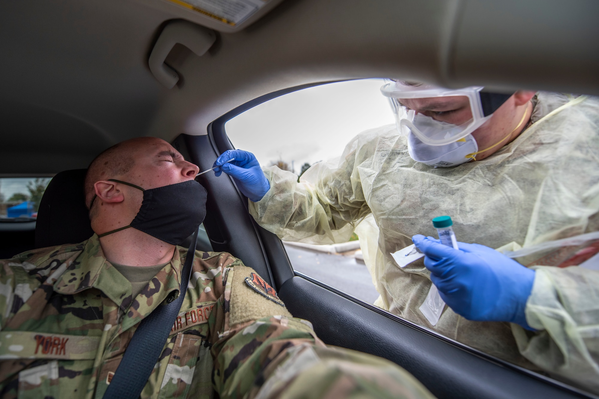 U.S. Army Pfc. Kaitlin Conway, a Soldier assigned to the Ohio National Guard, conducts a COVID-19 test during a pop-up testing drive-thru at Anthony Wayne Junior High School in Whitehouse, Ohio, Oct. 19, 2020.