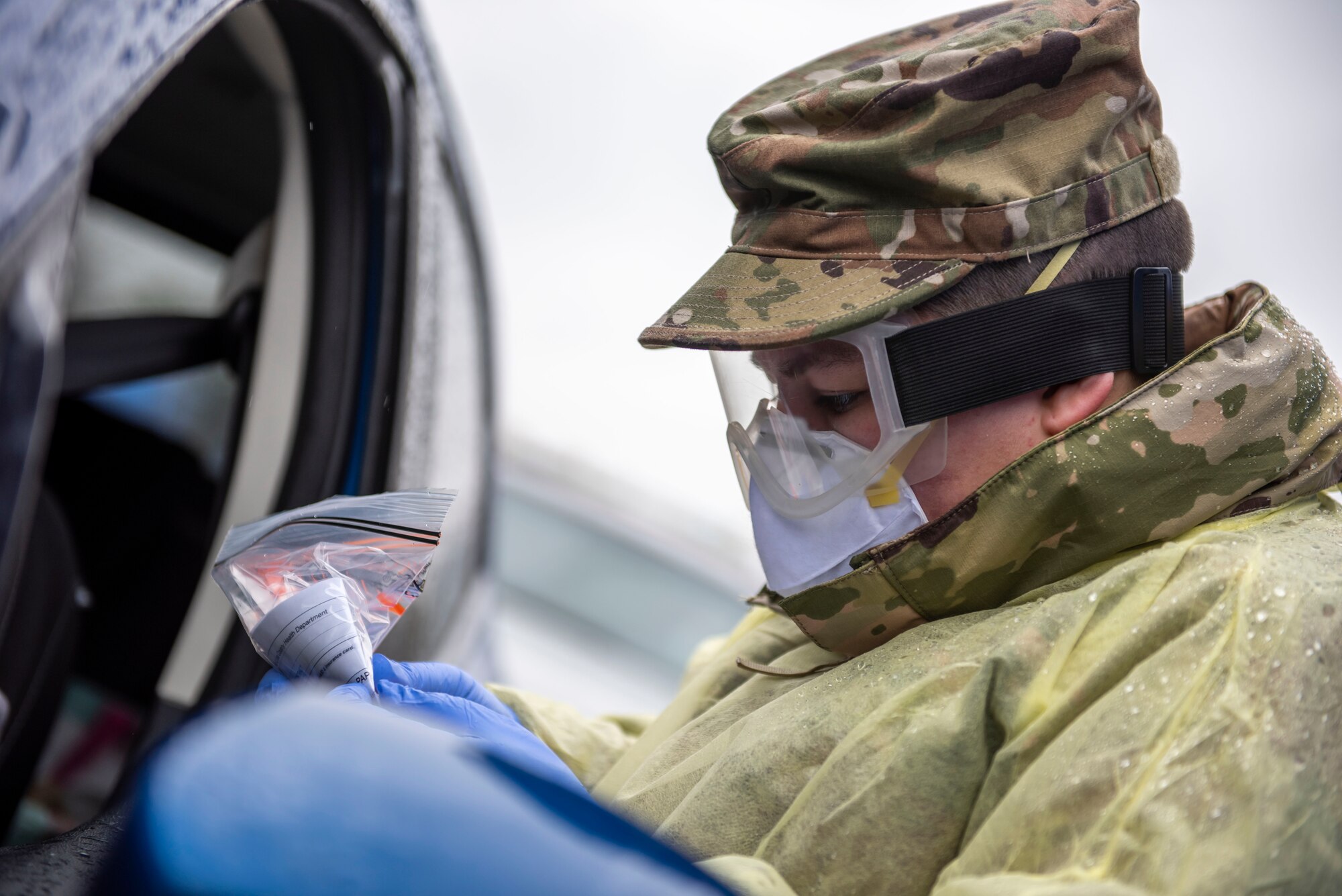 U.S. Army Pfc. Kaitlin Conway, a Soldier assigned to the Ohio National Guard, conducts a COVID-19 test during a pop-up testing drive-thru at Anthony Wayne Junior High School in Whitehouse, Ohio, Oct. 19, 2020.