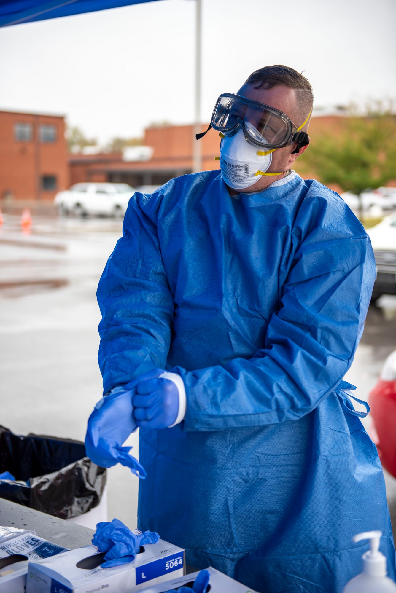 Cpl. Gene Meabon, a Soldier assigned to the Ohio Military Reserve, puts on new gloves before conducting a COVID-19 test during a pop-up testing drive-thru at Anthony Wayne Junior High School in Whitehouse, Ohio, Oct. 19, 2020.