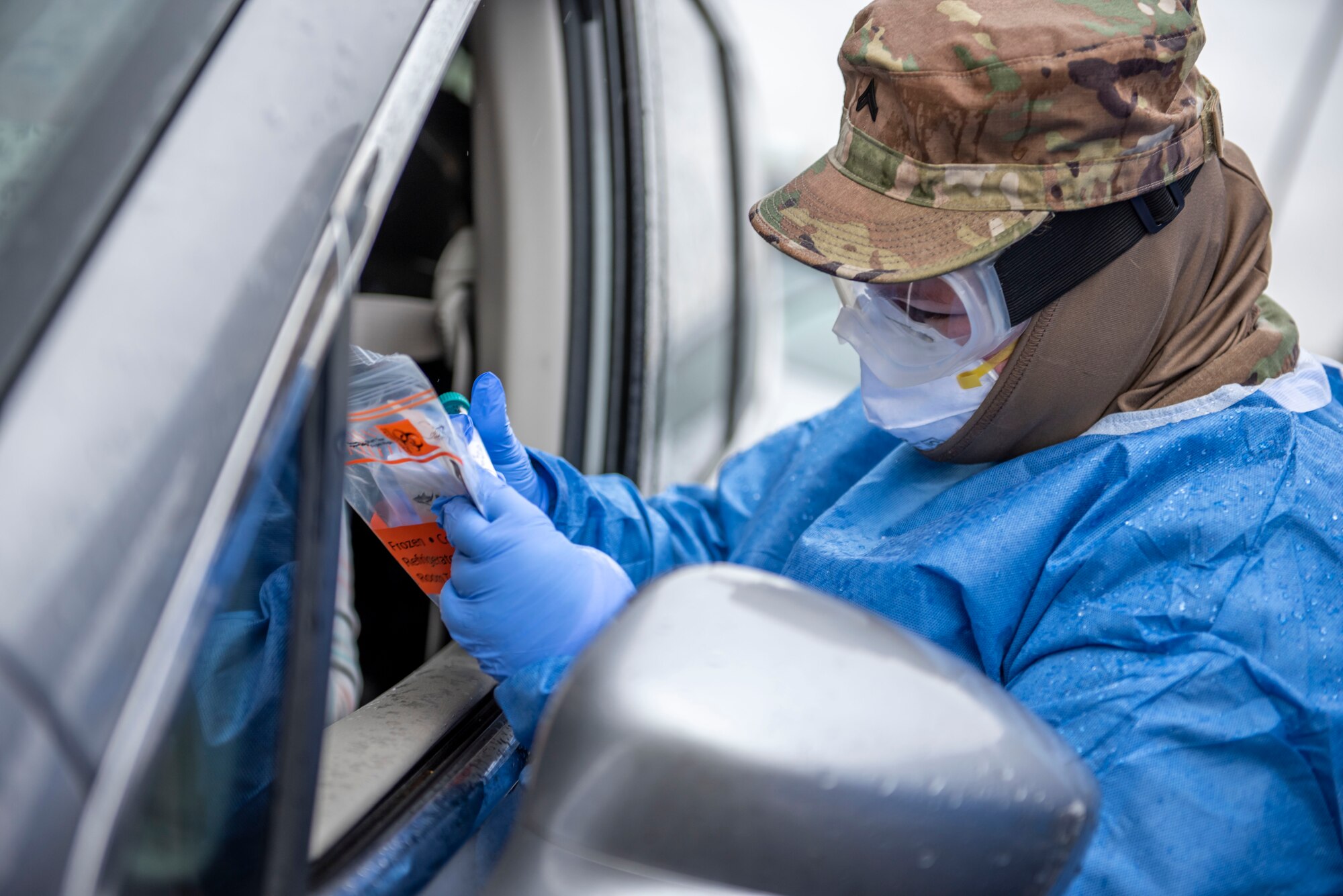 Cpl. Nikki Sherman, a Soldier assigned to the Ohio Military Reserve, conducts a COVID-19 test during a pop-up testing drive-thru at Anthony Wayne Junior High School in Whitehouse, Ohio, Oct. 19, 2020.