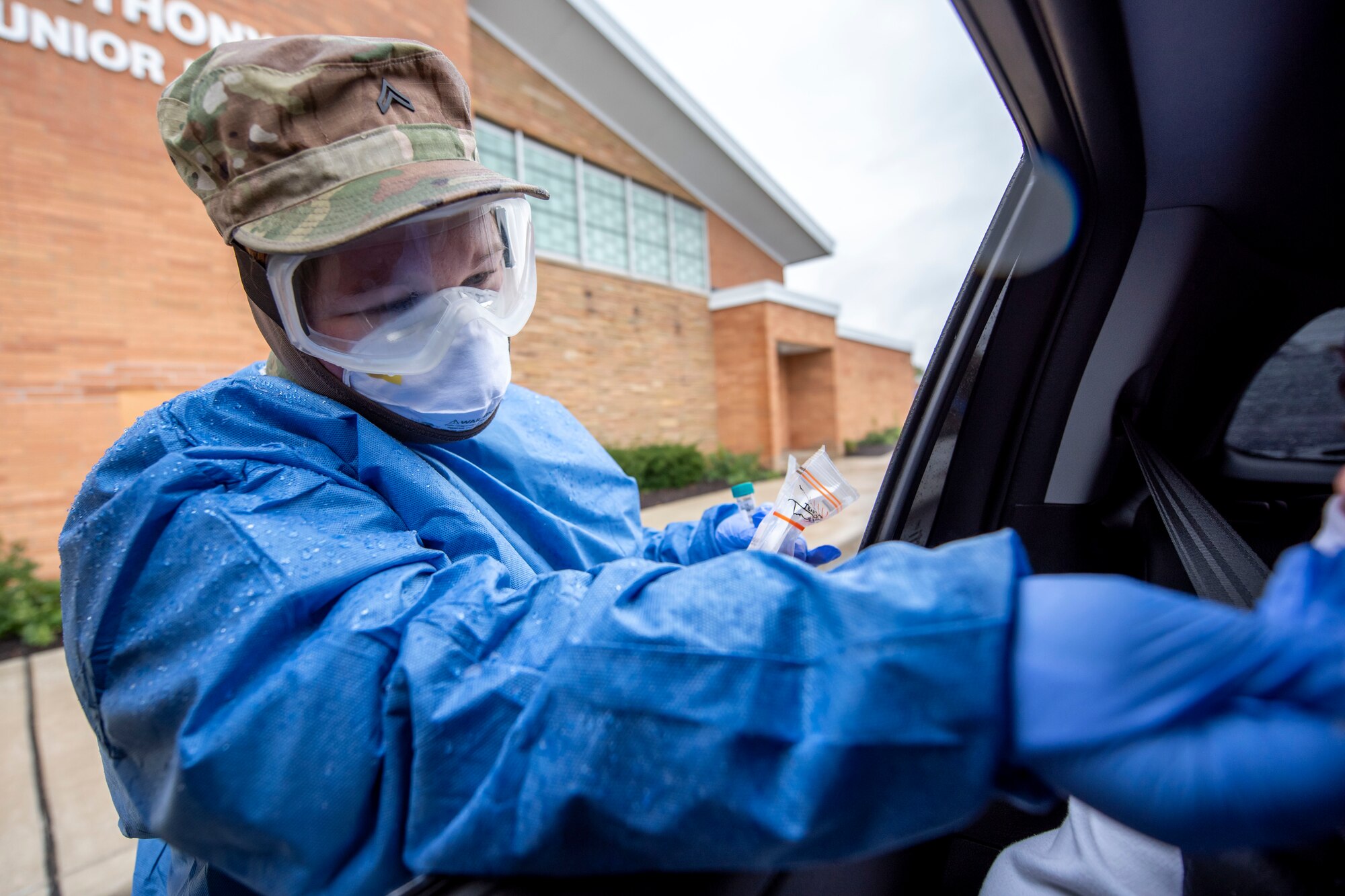 Cpl. Nikki Sherman, a Soldier assigned to the Ohio Military Reserve, conducts a COVID-19 test during a pop-up testing drive-thru at Anthony Wayne Junior High School in Whitehouse, Ohio, Oct. 19, 2020.