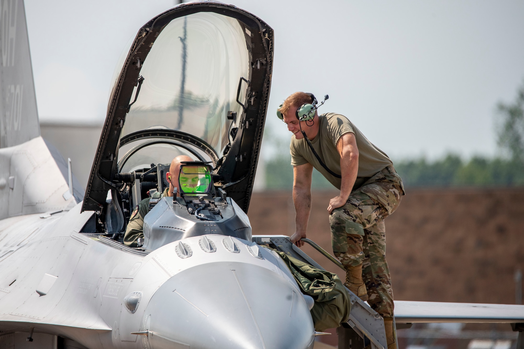 U.S. Air Force Airman 1st Class Liam McDonald, a crew chief assigned to the Ohio National Guard's 180th Fighter Wing, prepares Capt. Joshua Caudill, an F-16 fighter pilot assigned to the 180FW, prepare for a training flight at the 180FW in Swanton, Ohio, Aug. 27, 2020.